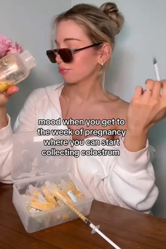 A woman wearing sunglasses poses with a container of colostrum-filled syringes.