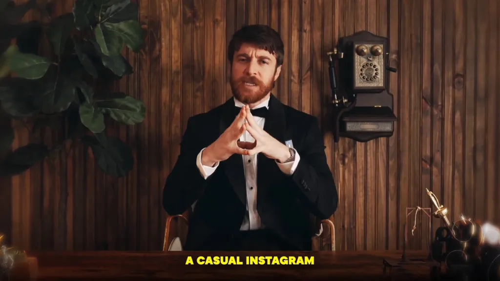 Hayden McDougall in a black suit with a bow tie, hands clasped, in front of a wooden panel wall.