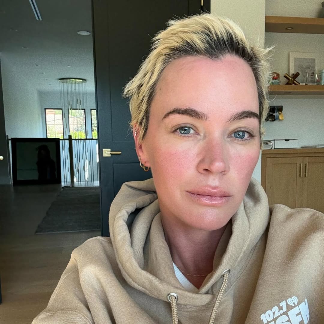 Teddi Mellencamp looks directly at the camera, wearing a tan hoodie, as she updates fans on her health.