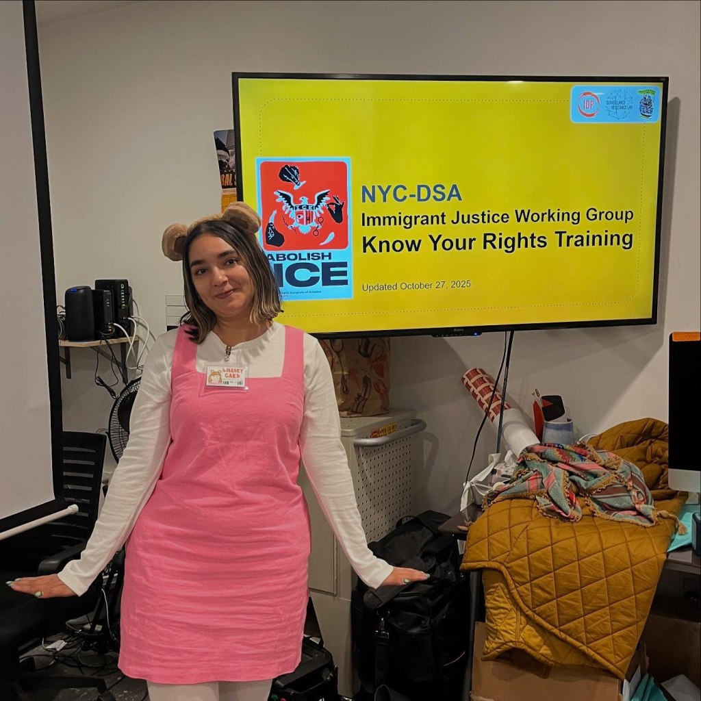 DSA member and and Anti-Ice supporter Leemah. in a pink and white dress in front of a yellow screen