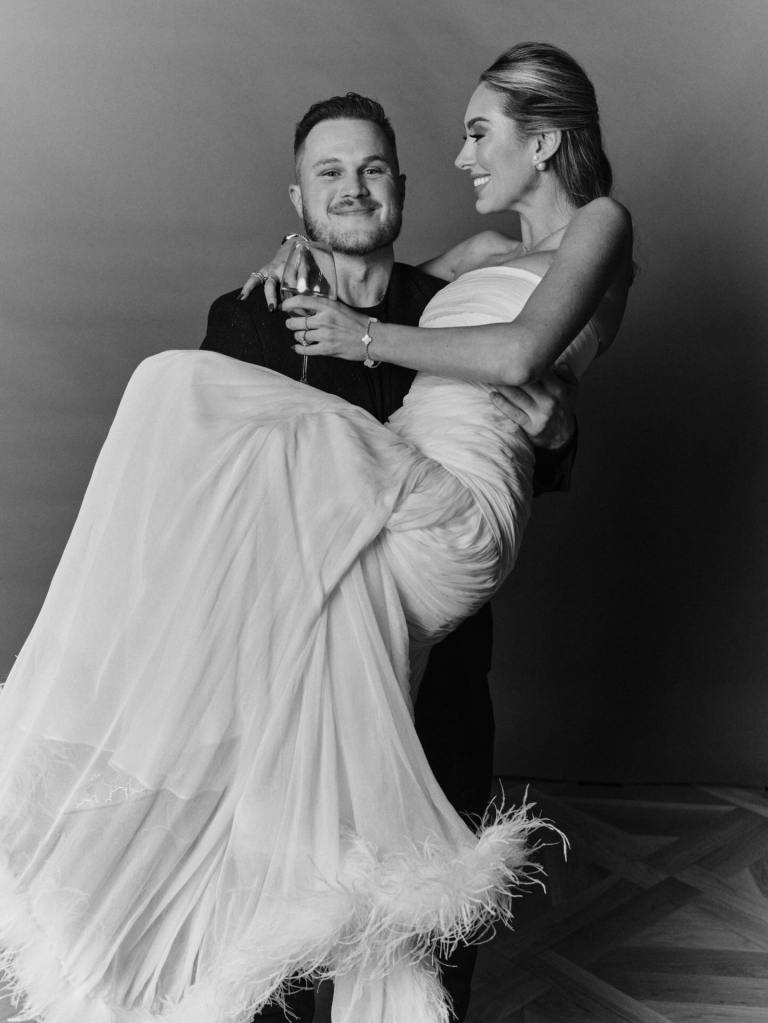 Black and white photo of a Zach Bryan holding a Samantha Leonard in a wedding dress.