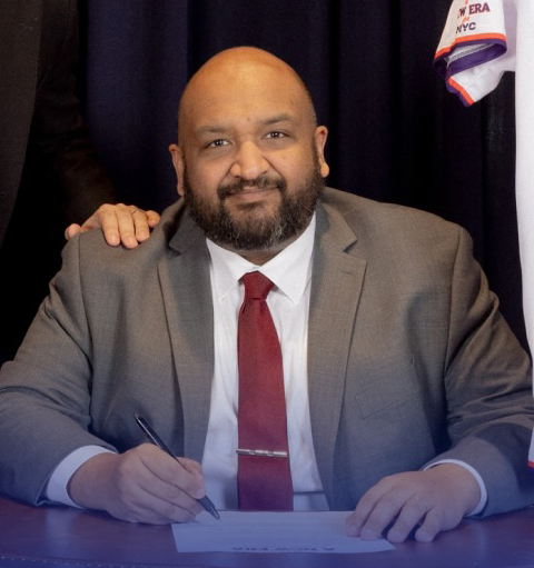 Ahmed Tigani signing a document.
