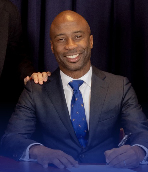 Kamar Samuels, NYC Schools Chancellor, signs documents.