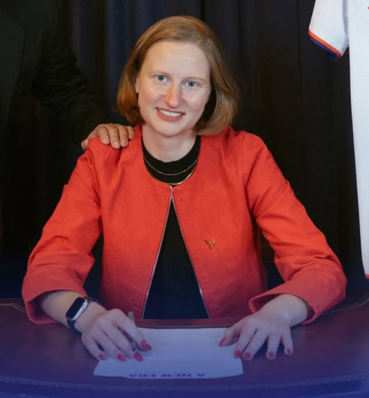 Cea Weaver at a desk, smiling with a hand on her shoulder.