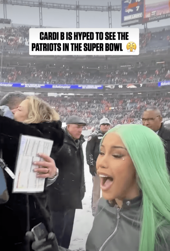 Cardi B in a stadium in the snow, reacting to an announcement.