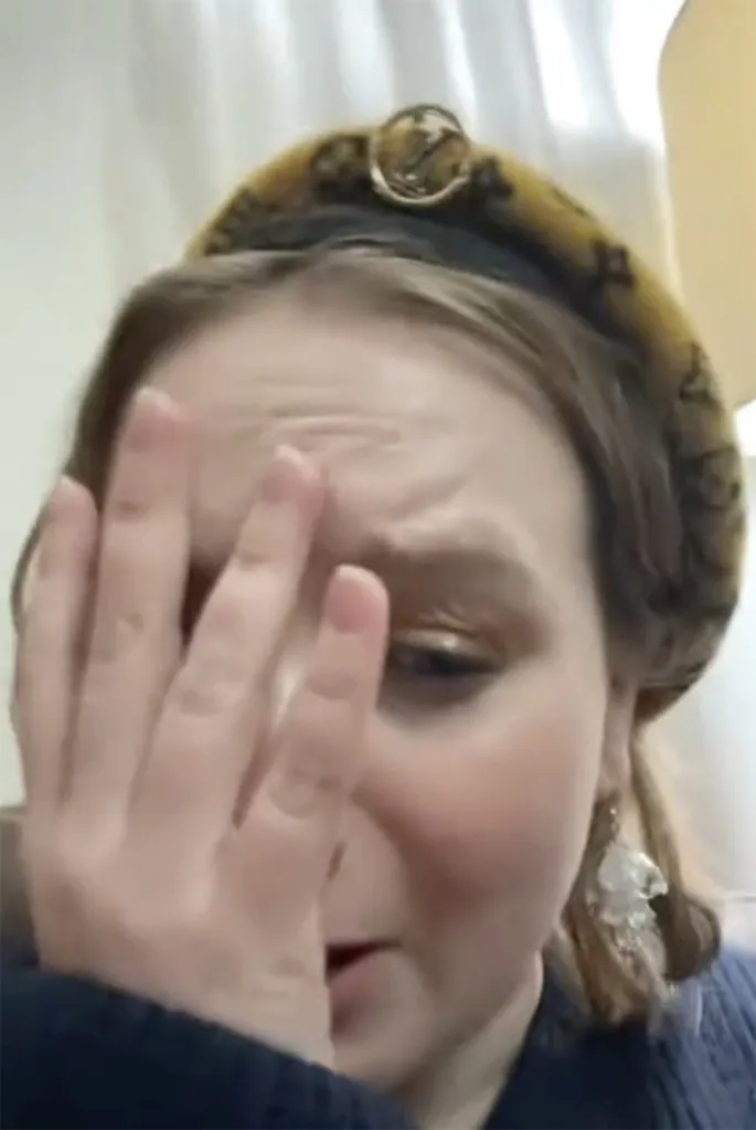 A woman with her hand covering her face.