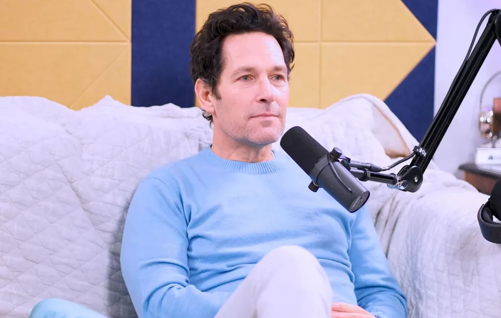 Paul Rudd sitting on a couch next to a microphone.