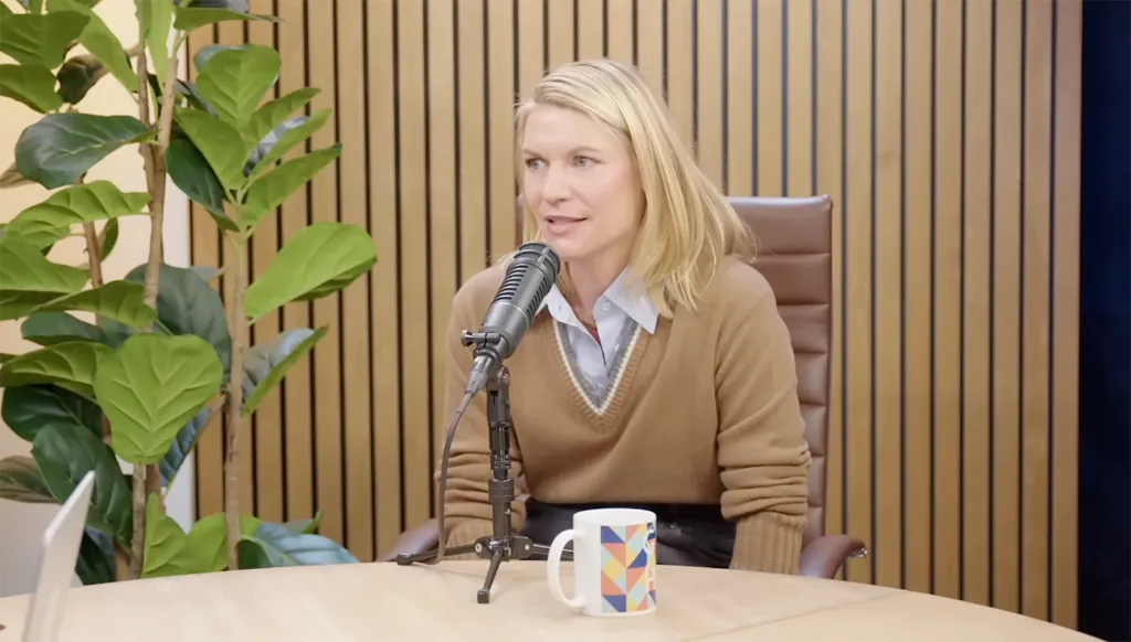 Claire Danes speaking into a microphone during a podcast recording.