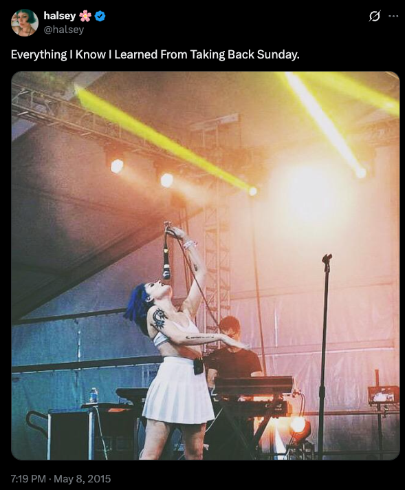 Halsey performing live on stage with a microphone.