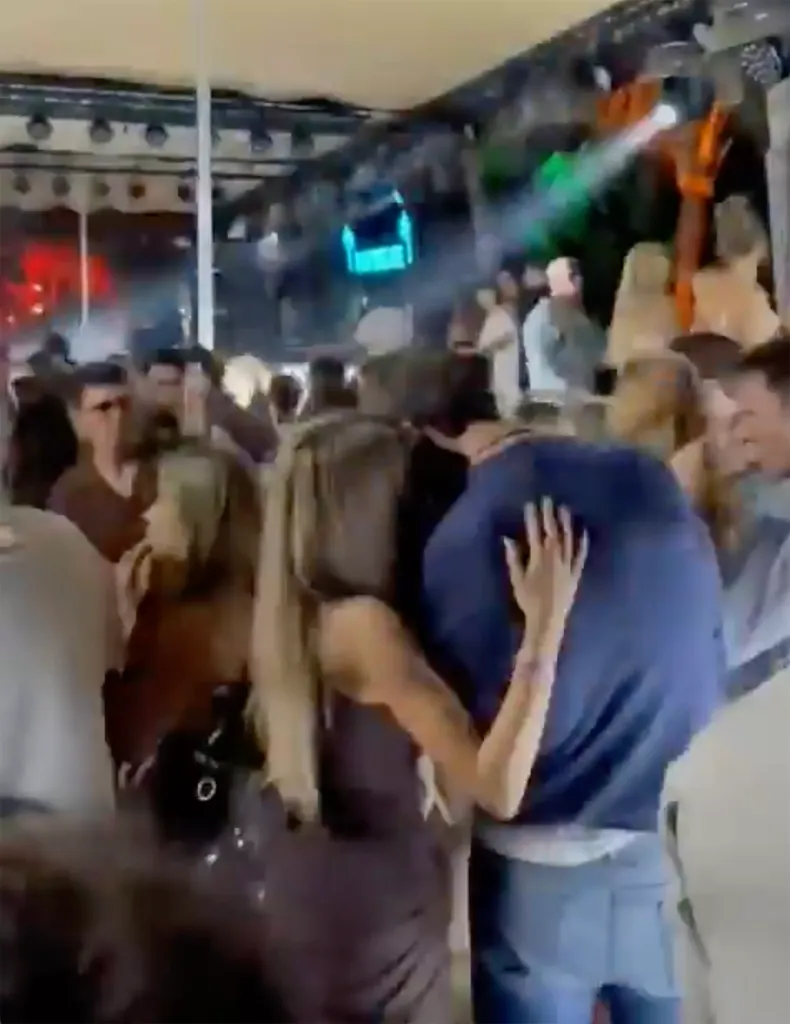 Alix Earle with her arms around Tom Brady at a New Year's Eve party.