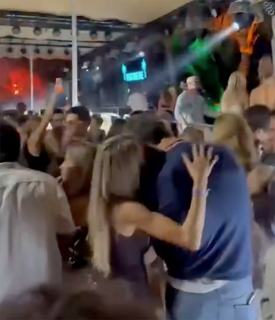 Alix Earle and Tom Brady dancing closely in a crowded club.