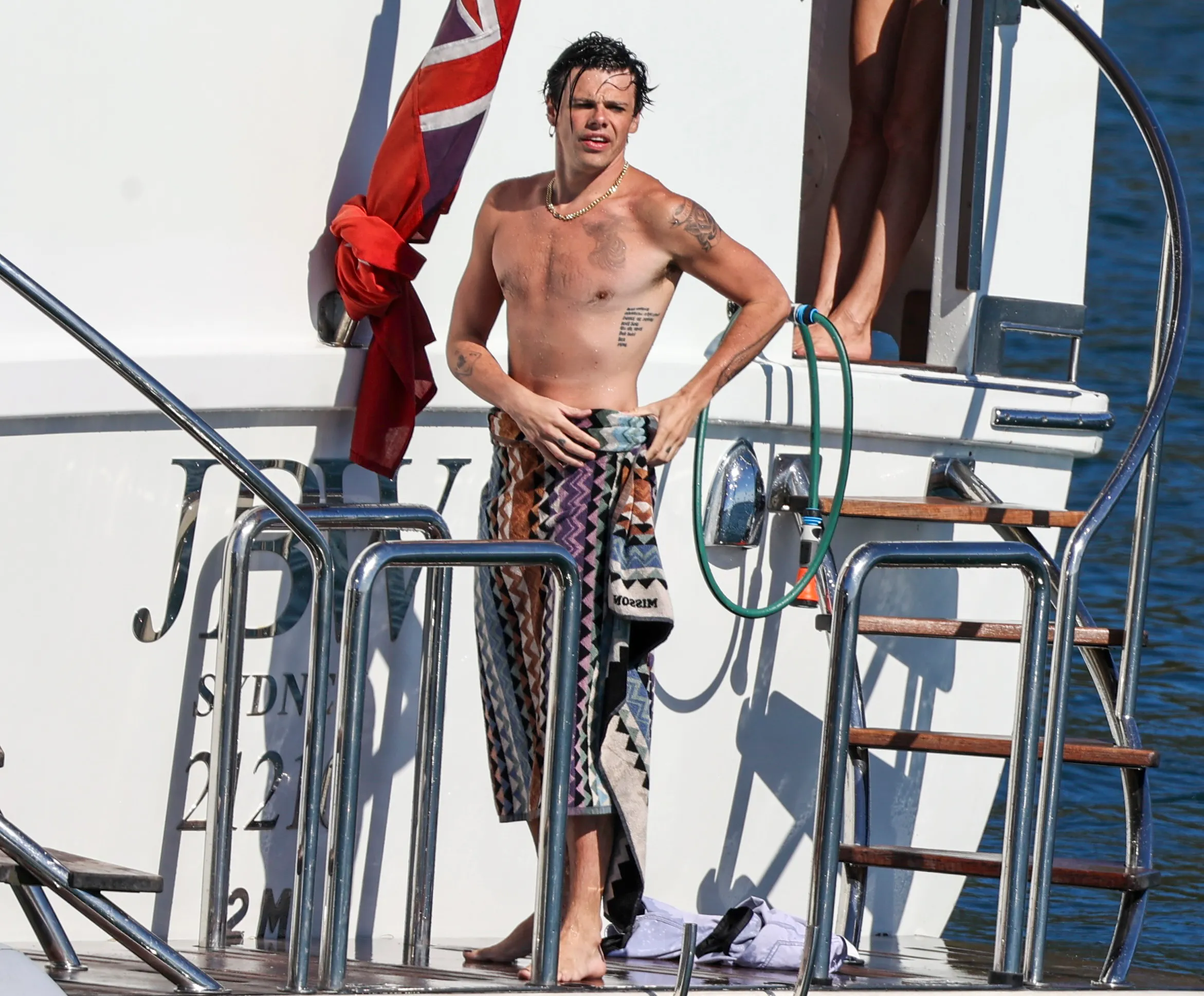 Yungblud on a yacht, drying off with a towel.