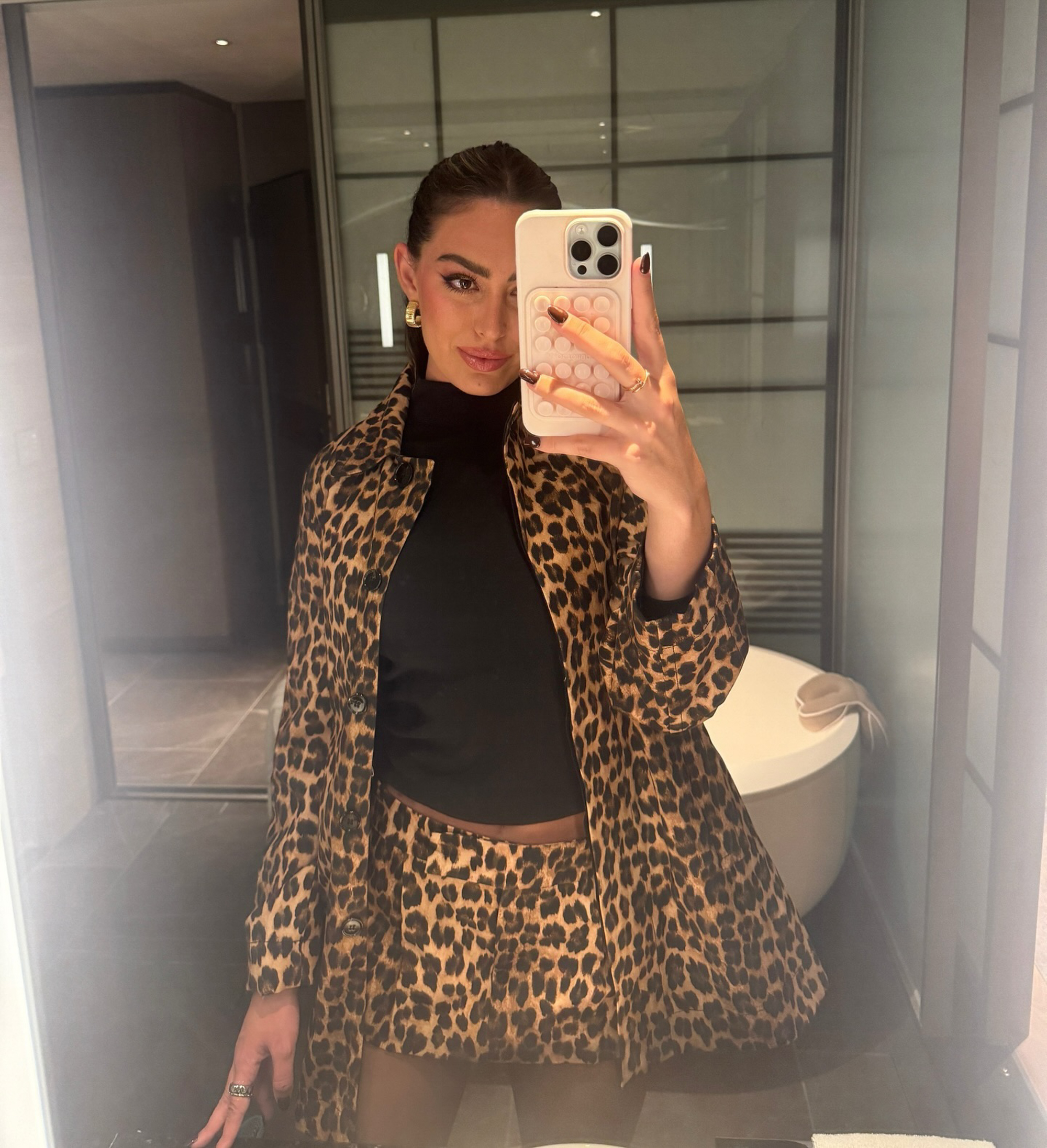 Samantha Leonard takes a mirror selfie wearing a leopard print jacket and skirt.
