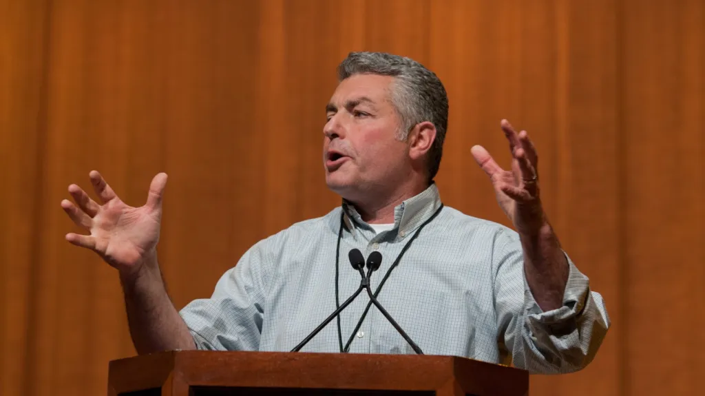 Dave Regan speaking at a podium.