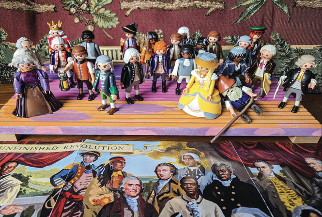reader-submitted photo of diorama with Playmobil figures arranged in same order + appearance as figures on cover of November 2025 Atlantic, seen at bottom