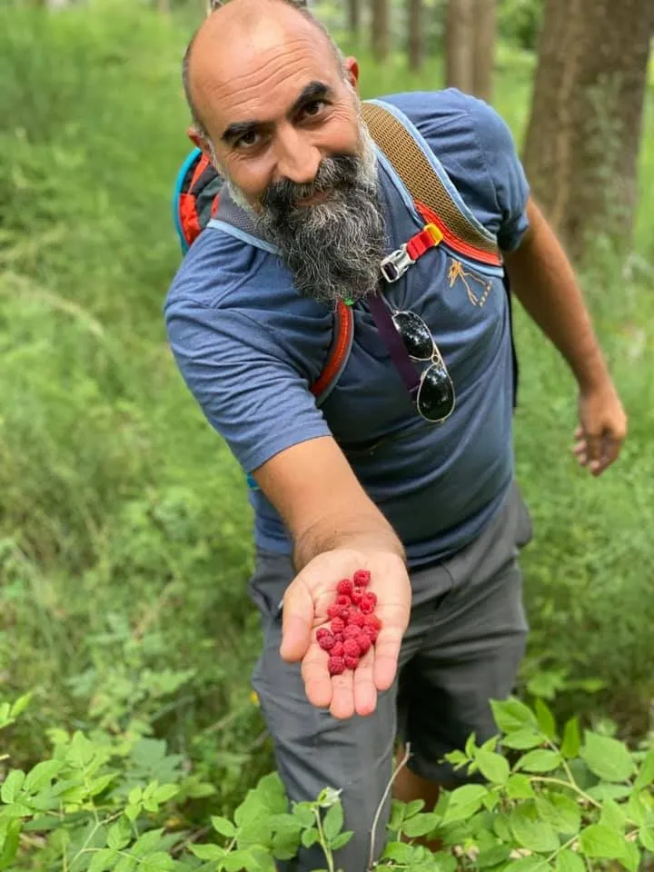 Tommaso Cioni holding a handful of freshly picked raspberries.