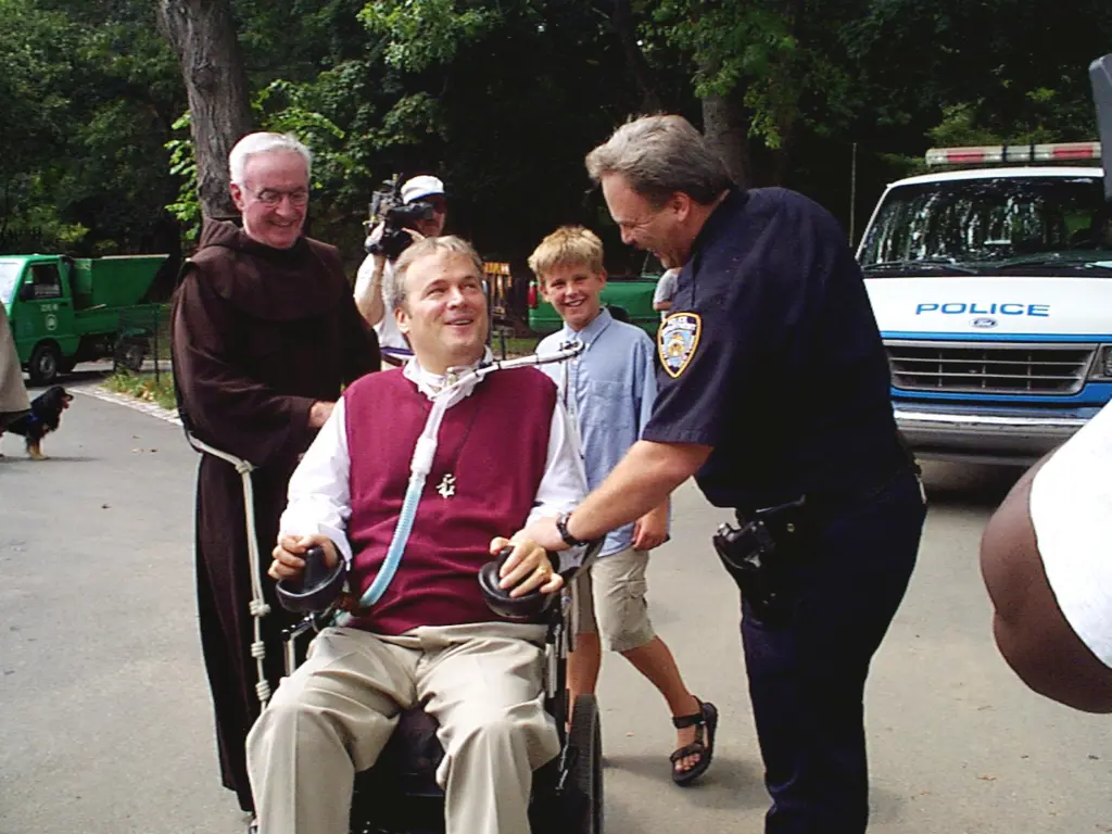 Det. Steven McDonald in a wheelchair, with his son Conor and priest Mychael Judge, chatting with POSteven Fuchs.
