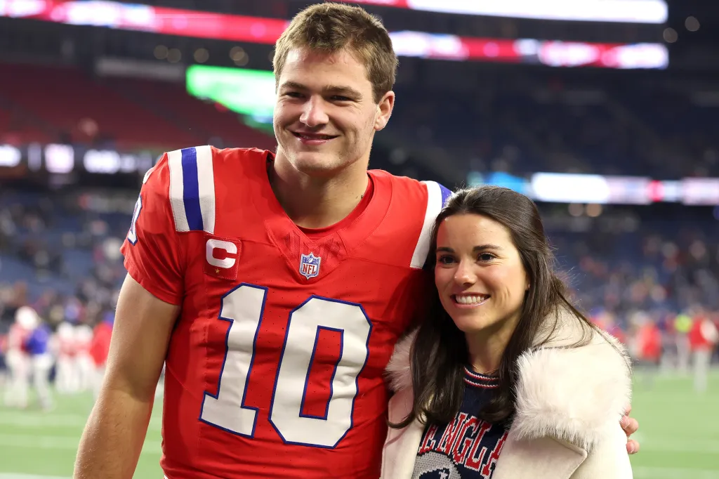 Mac Jones in uniform and his girlfriend Sophie Scott posing for a photo.