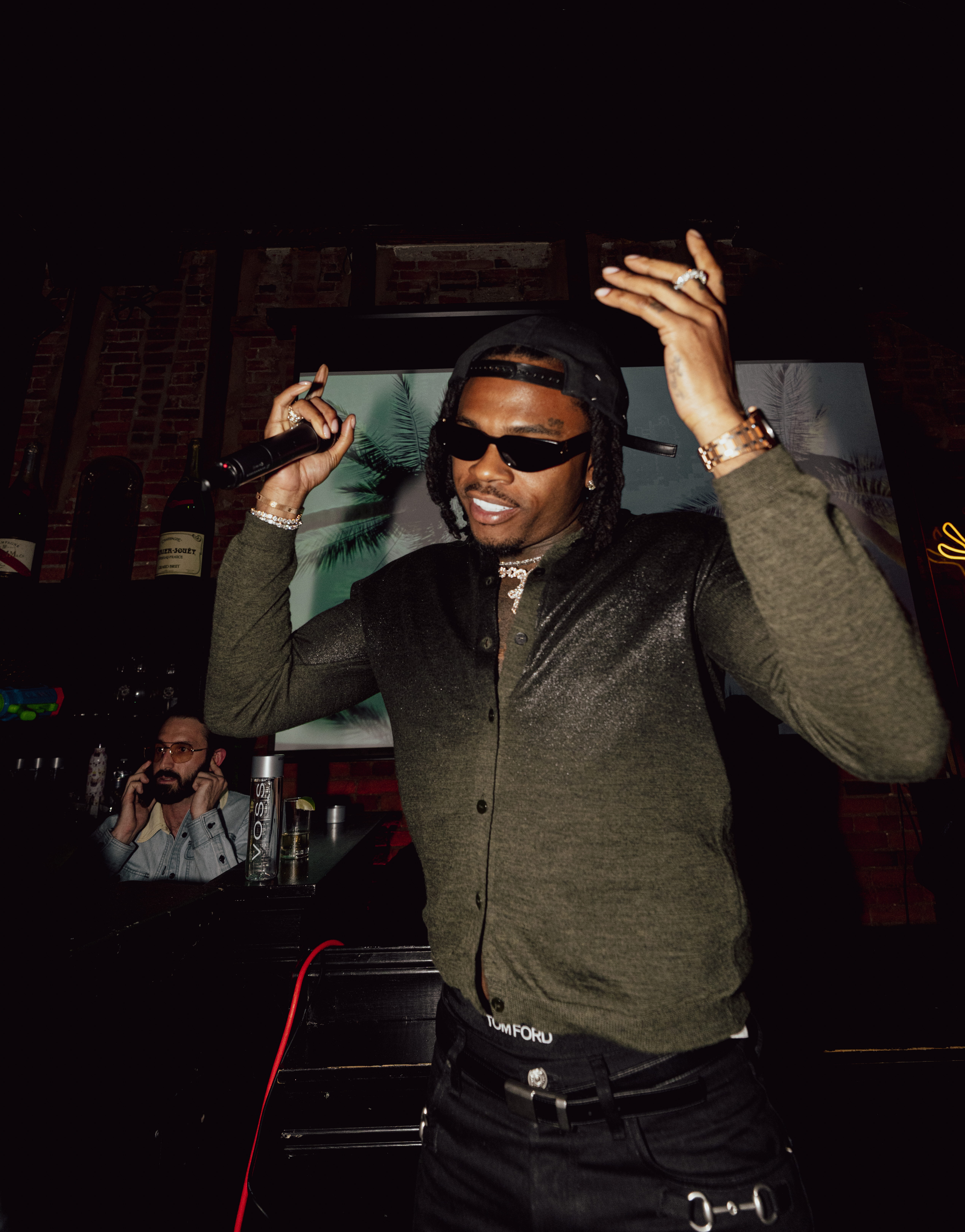 Gunna performing on stage, holding a microphone.