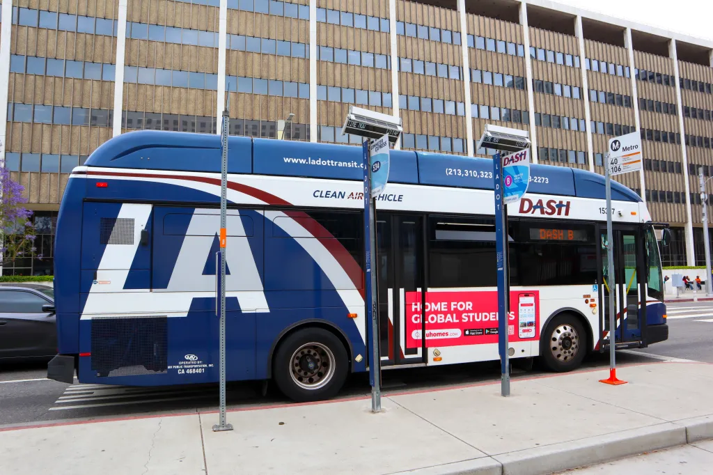 Blue and white LADOT Transit DASH bus parked at a bus stop in Los Angeles.