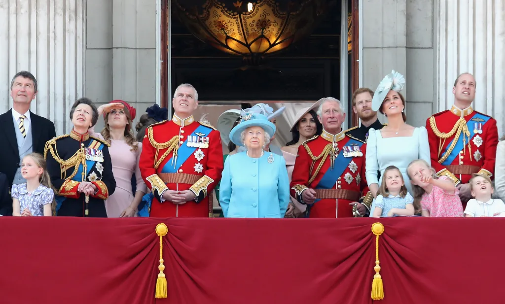 The British Royal Family, including Queen Elizabeth II, Prince Charles, Prince William, and Prince Harry, watch a flypast from the Buckingham Palace balcony.