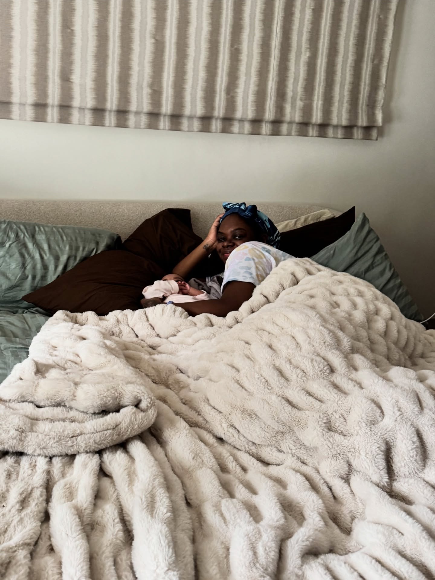 Cori Broadus lying in bed with her baby girl.