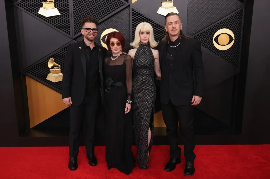 Jack Osbourne, Sharon Osbourne, Kelly Osbourne, and Sid Wilson pose on the red carpet.