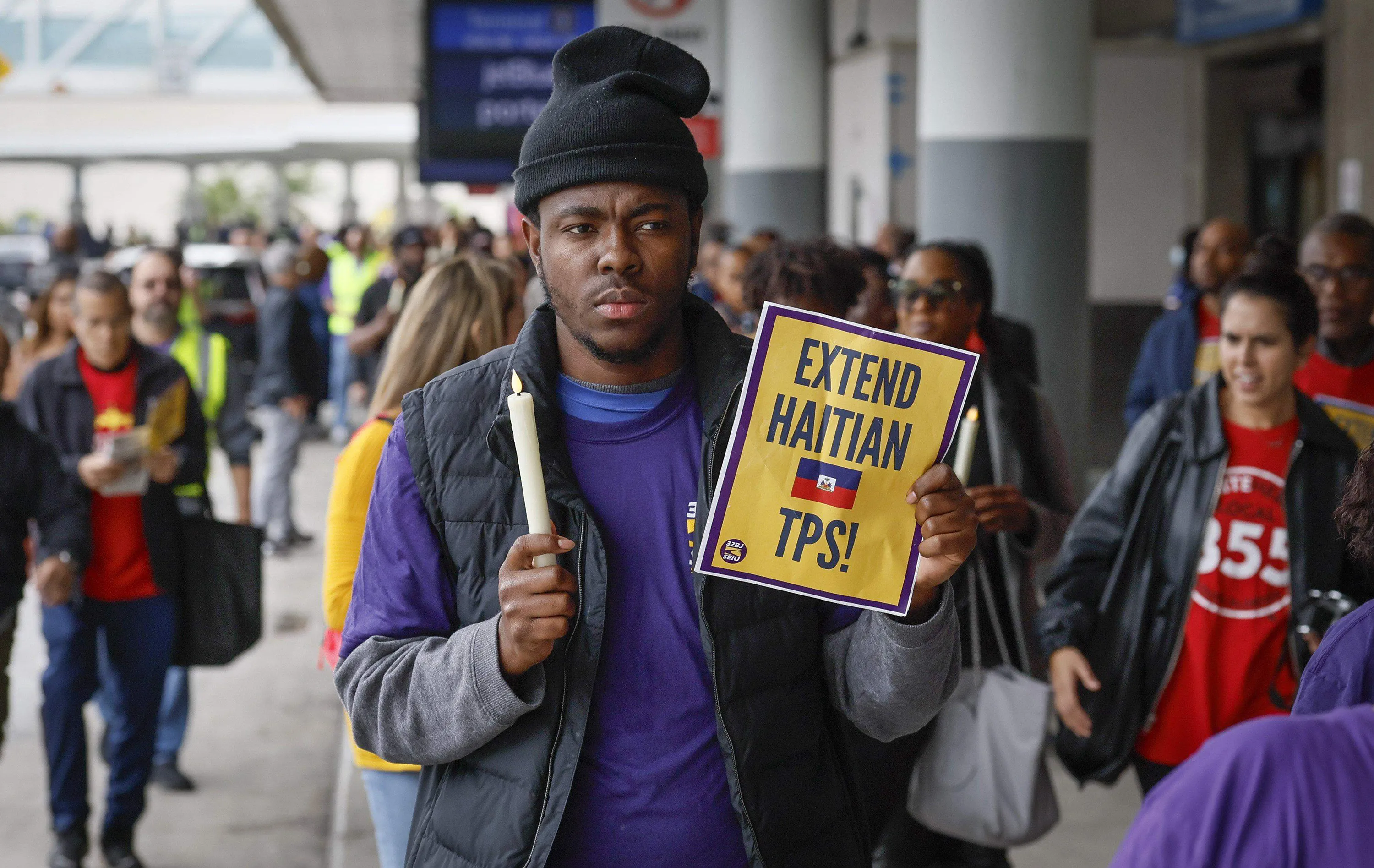 Yronel Cabrerra walks with protesters during a candlelight vigil and interfaith prayer at Fort Lauderdale-Hollywood International Airport on Jan. 28, 2026, as airport workers and faith leaders rally calling on the federal government to extend Temporary Protected Status for Haitians.