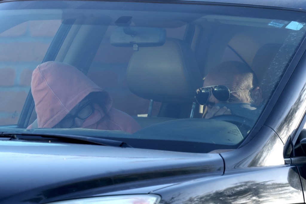 Savannah Guthrie's sister Annie in a pink hoodie and her husband Tommaso driving a car.