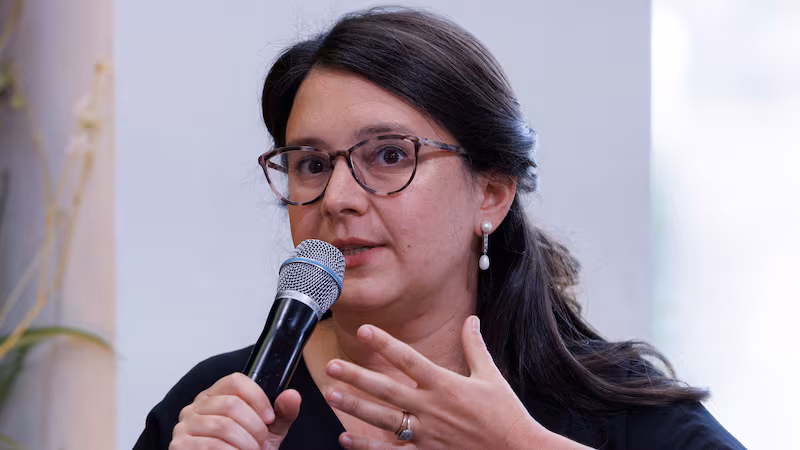 Bari Weiss holds a microphone up to his mouth in a photo 