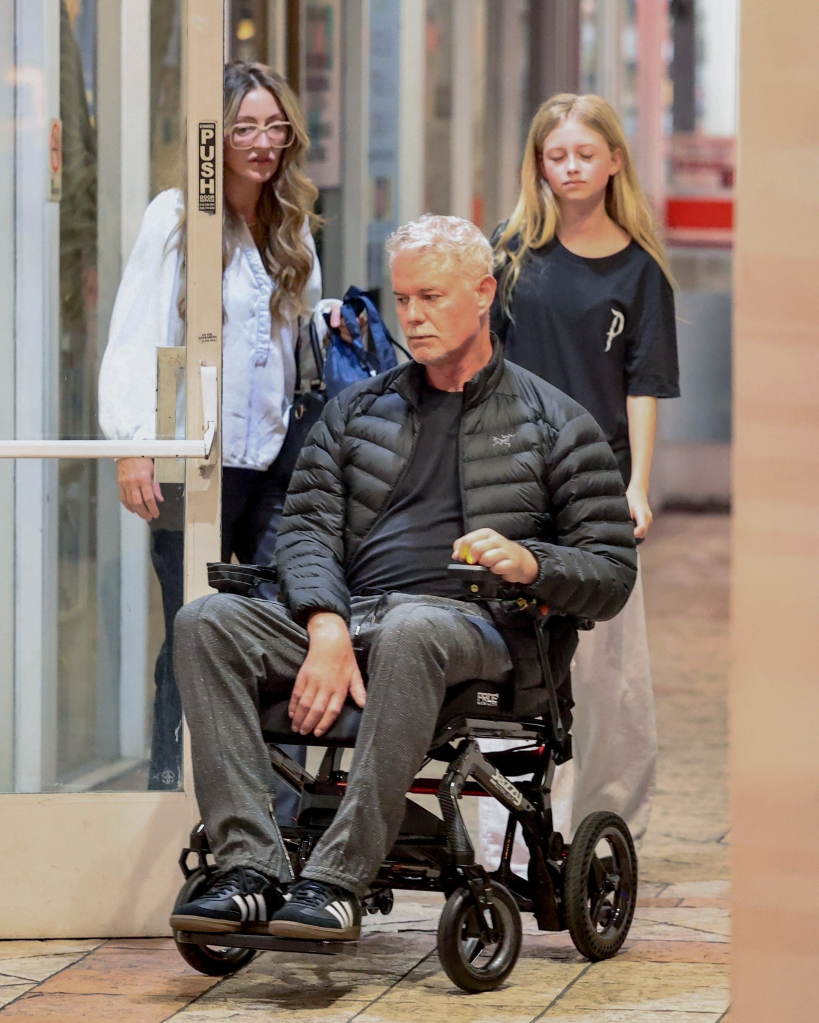 Eric Dane in a wheelchair with Rebecca Gayheart opening a door and Georgia Dean walking behind them.