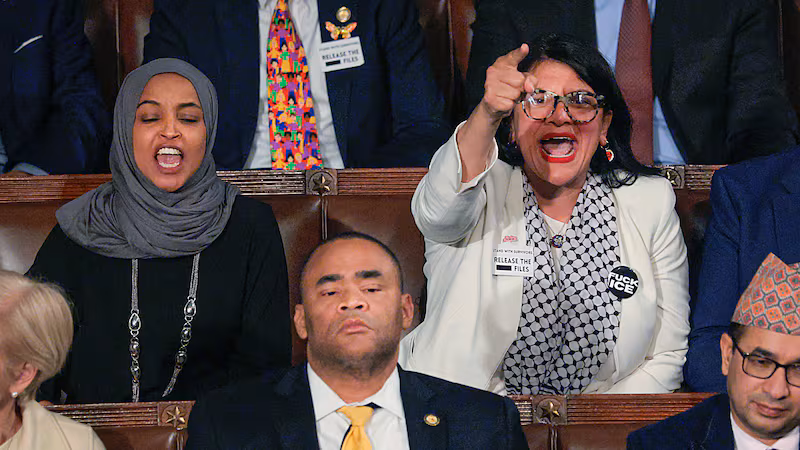 WASHINGTON, DC - FEBRUARY 24: Rep. Rashida Tlaib (D-MI) (R) and Rep. Ilhan Omar (D-MI) shout during U.S. President Donald Trump's State of the Union address during a Joint Session of Congress at the U.S. Capitol on February 24, 2026, in Washington, DC. Trump delivered his address days after the Supreme Court struck down the administration's tariff strategy and amid a U.S. military buildup in the Persian Gulf threatening Iran. (Photo by Chip Somodevilla/Getty Images)