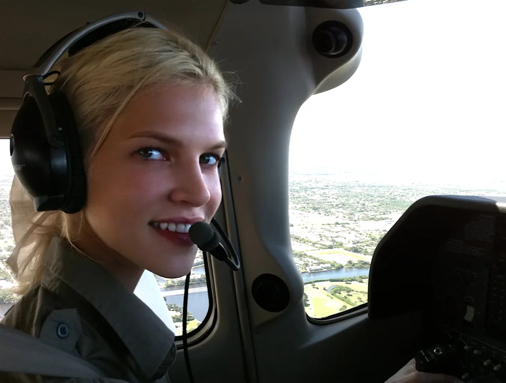 Pilot Nadia Marcinko in a cockpit wearing a headset.