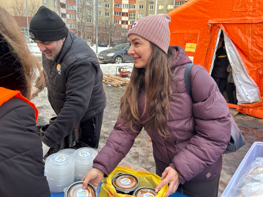 Olga Sukhobok, a sales manager, takes a container of hot soup provided by World Central Kitchen in Kyiv, Ukraine.