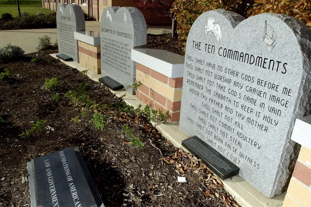 A granite monument displaying the Ten Commandments, the Declaration of Independence, and the Justinian Code outside Peebles High School.