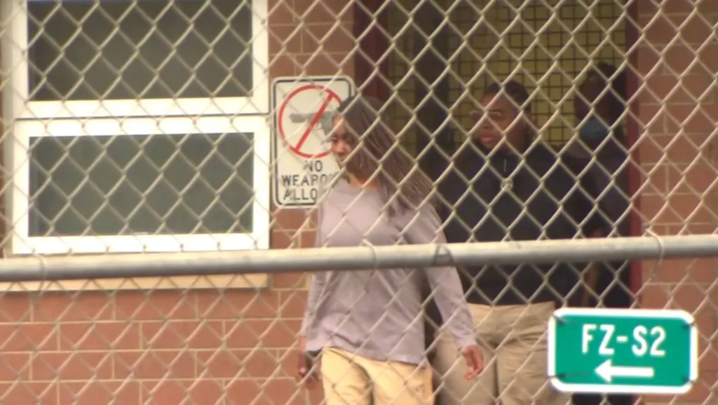 Crystal Mangum behind a chain-link fence, having been released from prison.