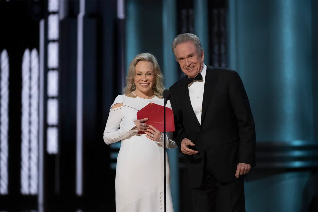 Faye Dunaway and Warren Beatty on stage, Dunaway holding a red envelope.