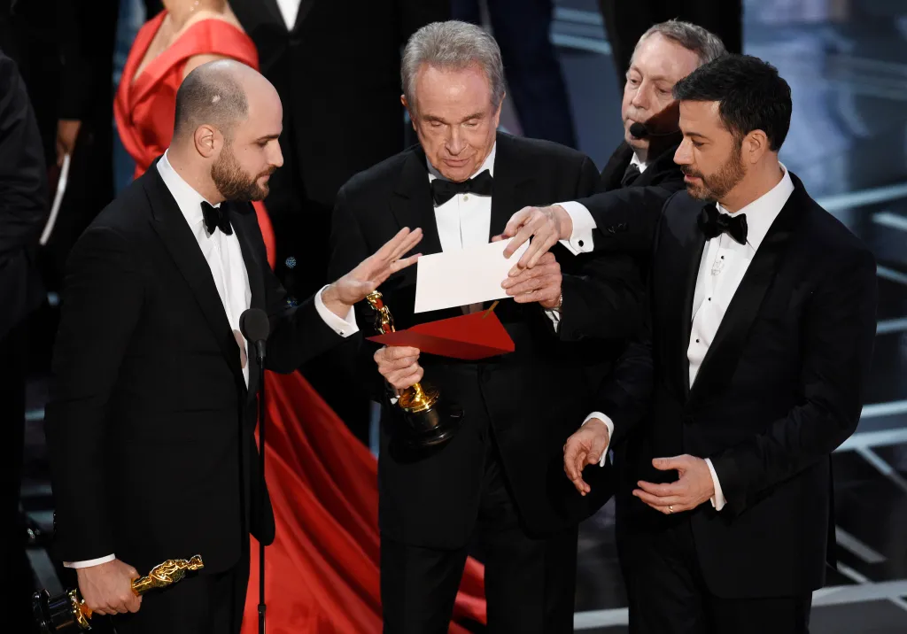 Jordan Horowitz, Warren Beatty, and Jimmy Kimmel look at an envelope announcing 