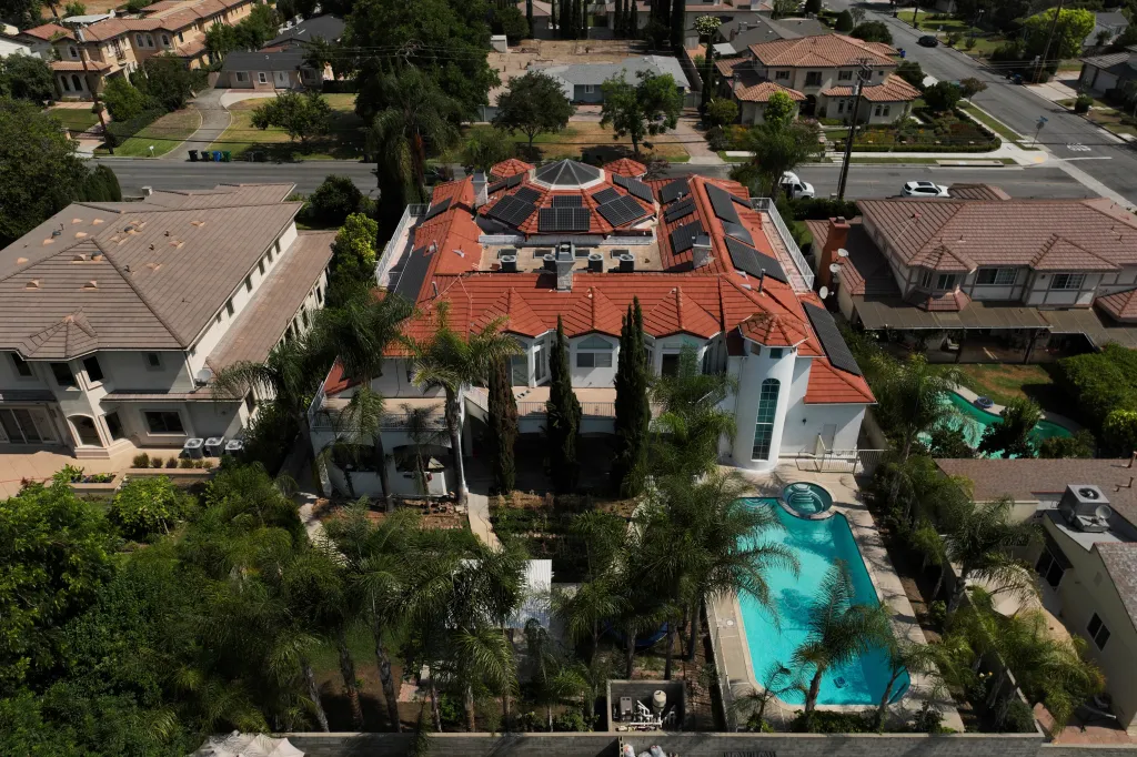 Aerial view of the home of Silvia Zhang and Guojun Xuan in Arcadia, California, featuring solar panels on a red-tiled roof and a swimming pool.