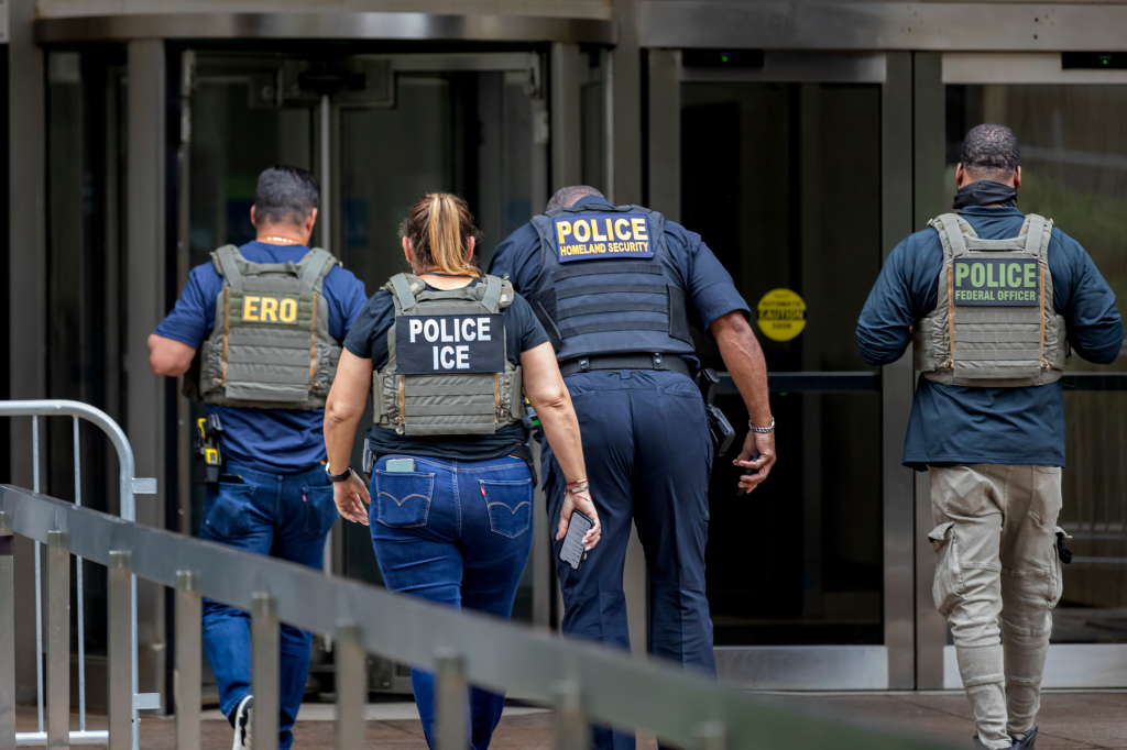 Four individuals wearing vests labeled