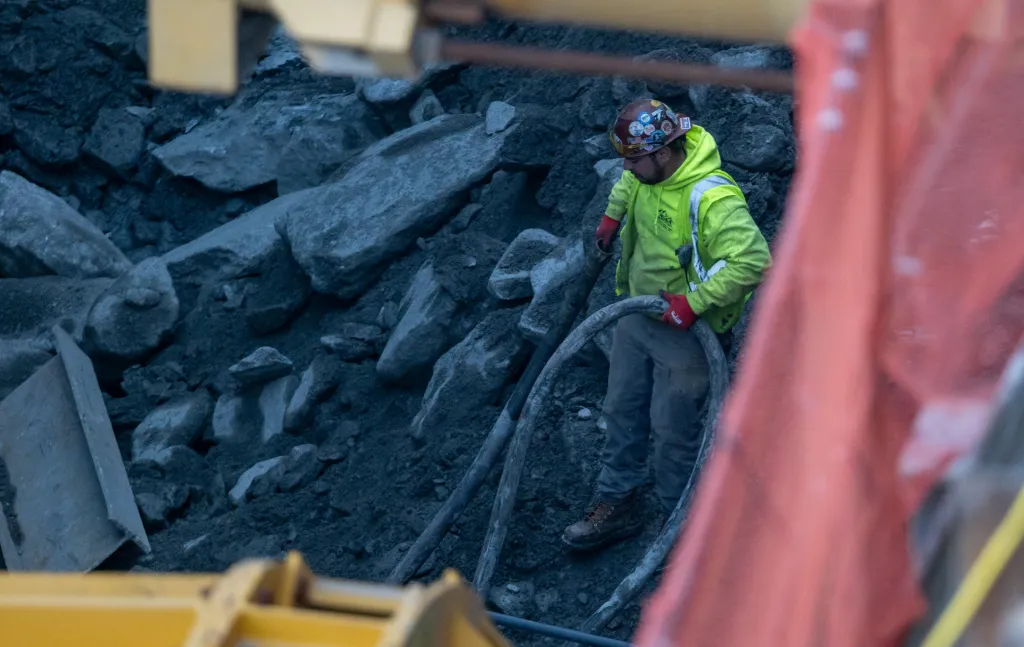 A construction worker in a yellow jacket and hard hat at the Hudson Gateway Tunnel site.