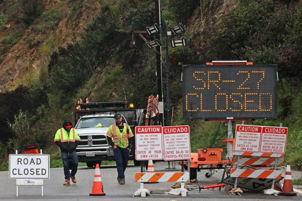 Two work crews in yellow safety vests at a road closure on State Route 27 in Topanga, California.