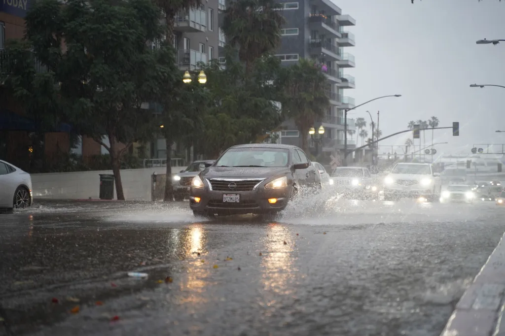 Cars driving through flooded streets during a rainstorm in San Diego.