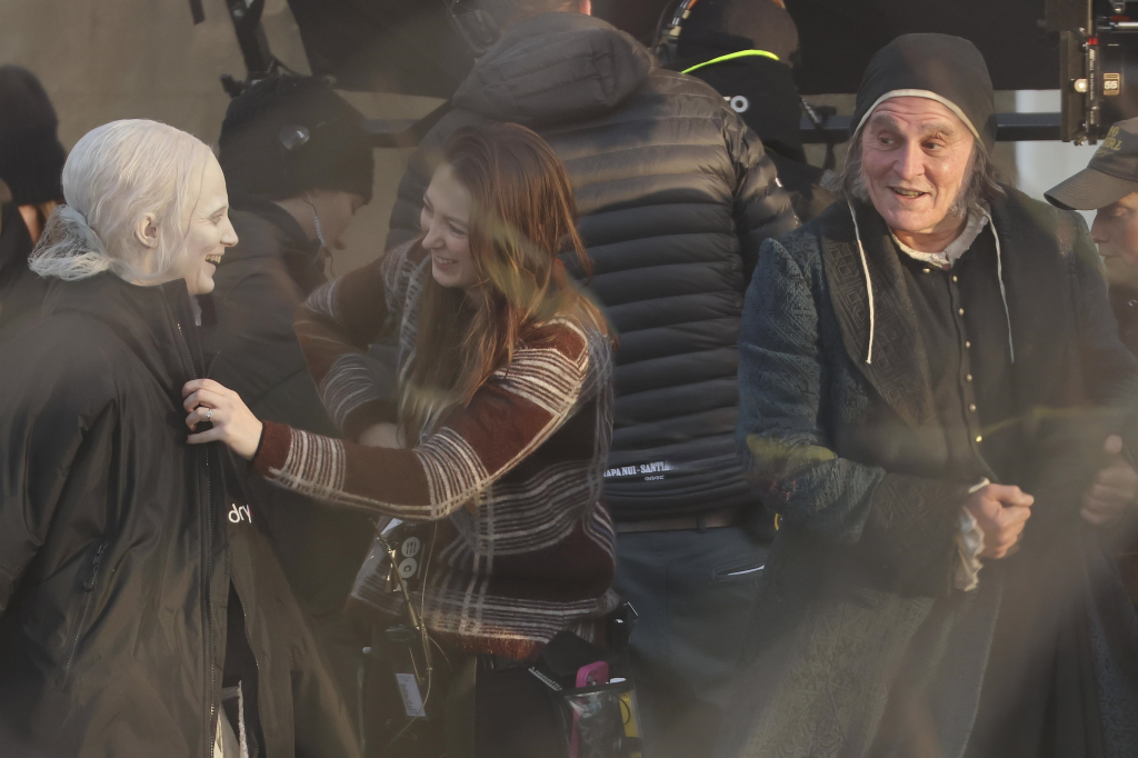 Johnny Depp in makeup as Ebenezer Scrooge, Andrea Riseborough in costume, and a crew member on the set of 