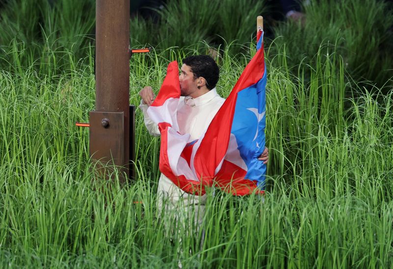Bad Bunny kissing the flag of Puerto Rico during the Super Bowl LX halftime show.