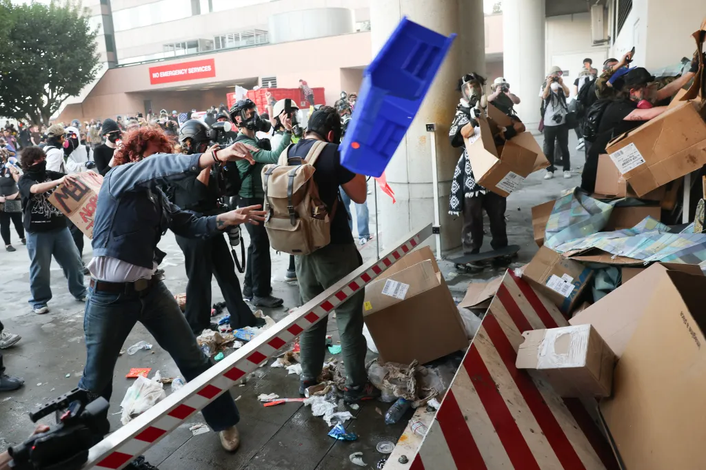 Protestors barricade police with garbage during a