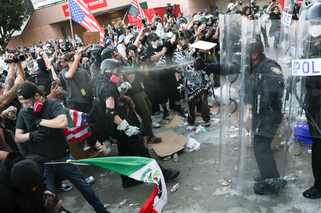 A police officer sprays a protestor with a chemical agent during an immigration protest.