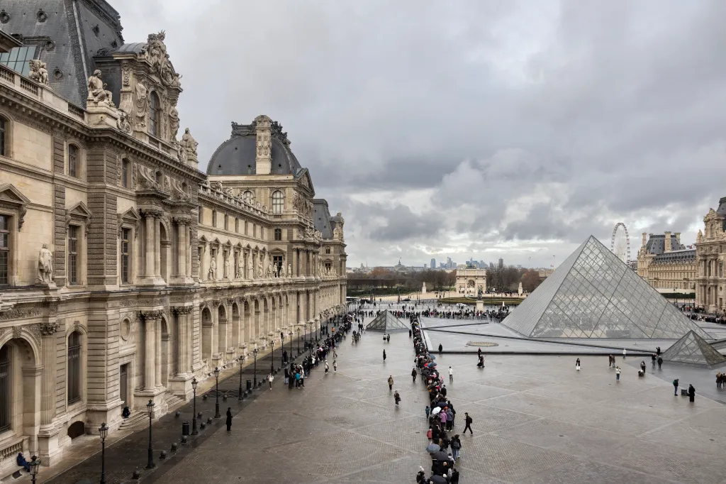 Visitors queue to enter the Louvre Museum in Paris.