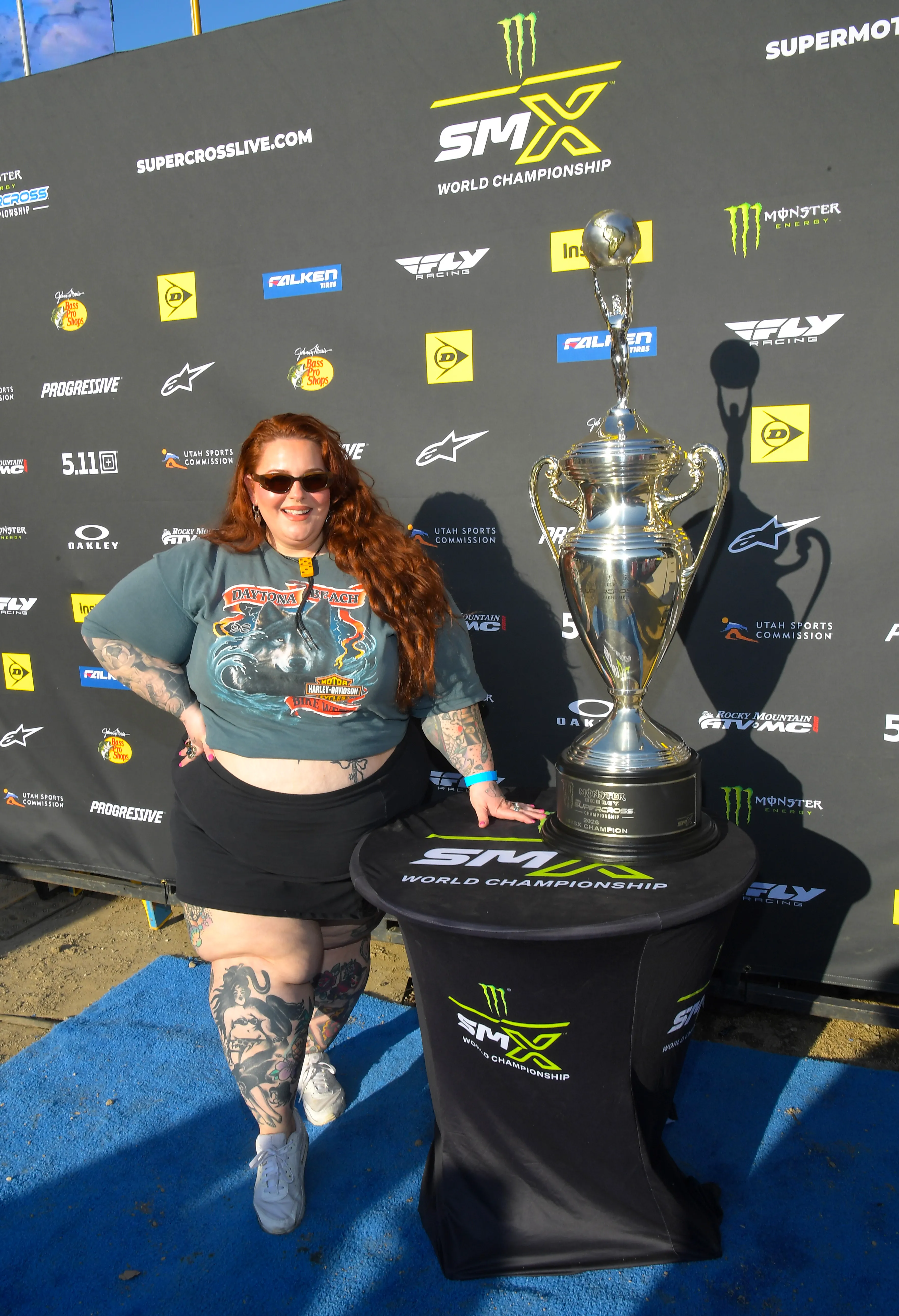 Tess Holliday attends the 2026 Monster Energy Supercross VIP Event, standing next to a large trophy.