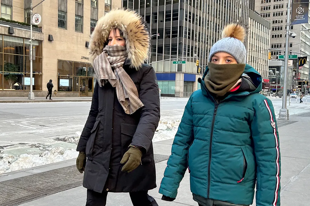 Two people are bundled up against freezing cold in Midtown Manhattan.